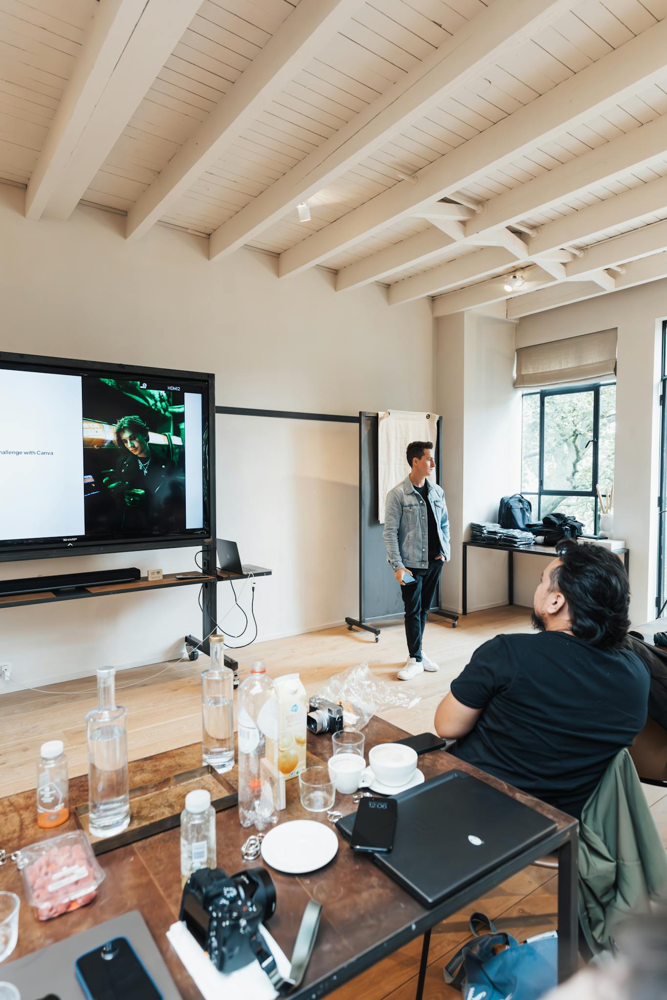 A casual business meeting with a presenter by a screen, indoors.